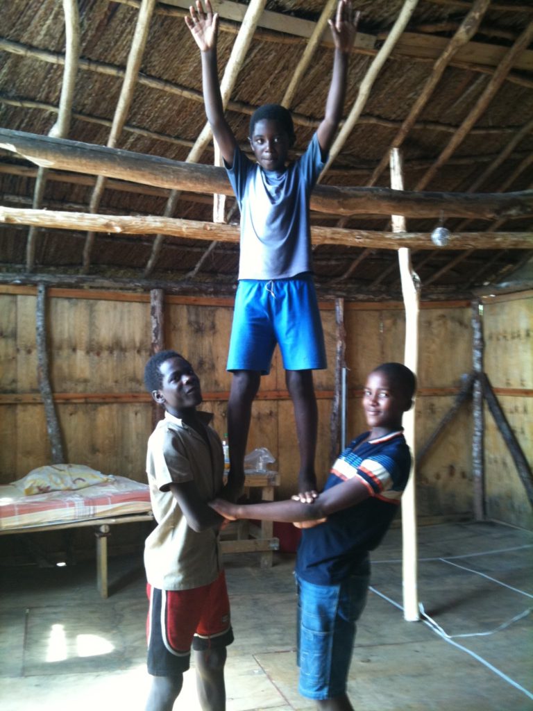 Three boys form a human triangle