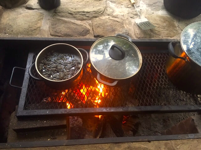 Pots cooking food over the outdoor fire